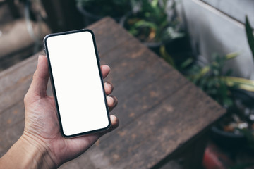 Mockup image blank white screen cell phone.man hand holding texting using mobile on desk at coffee shop.background empty space for advertise text.people contact marketing business,technology 