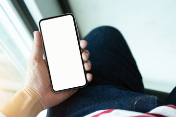 Mockup image blank white screen cell phone.man hand holding texting using mobile on desk at coffee shop.background empty space for advertise text.people contact marketing business,technology 