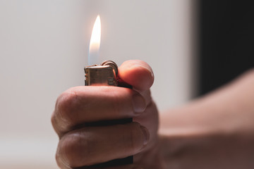 A woman lights a flame with a lighter - Powered by Adobe
