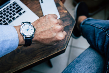 looking at luxury watch on hand check the time at workplace.concept for managing time organization...