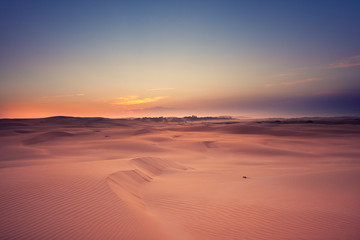 Fototapeta na wymiar Bright contrast desert landscape. Sunset. A chain of traces stretches to the horizon. Stockton Sand Dunes near the coast, Worimi Regional Park, Anna Bay, Australia