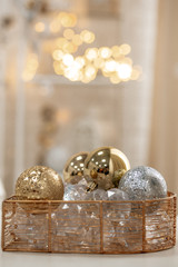 Basket with Christmas balls. Christmas balls of golden and silver color. Background from bokeh garlands of warm color.