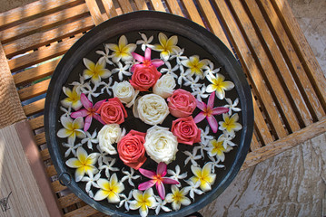 This unique picture shows a beautiful bowl with water and flowers floating in it as you find it in wellness oases