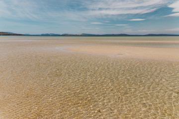 view of Dunalley Beach in Tasmania, Australia with sandbanks and shallow pristine water