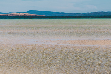 view of Dunalley Beach in Tasmania, Australia with sandbanks and shallow pristine water