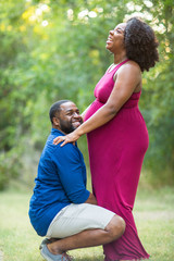 Naklejka na ściany i meble Portrait of a happy pregnant African American couple.