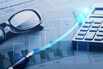 Calculator and glasses on company growth paper