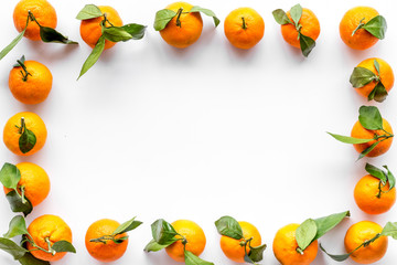Tangerines with leaves frame on white background top-down copy space