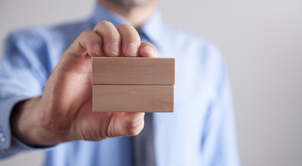 Businessman holding wooden empty blocks.