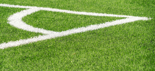 Green artificial grass turf soccer football field backgrond with white corner line boundary. Top view