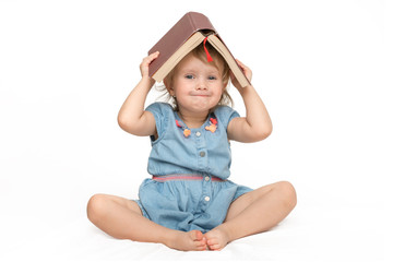 Cute little child in blue dress reading a book