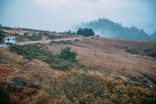 A bus running through foggy and bare landscape of Northern California