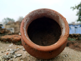 a red clay pot put on muddy place