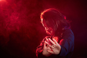 Portrait of chubby teen girl during photoshoot with colored smoke at night and black background