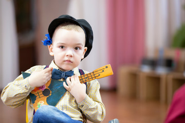 Russian boy with a balalaika. Funny preschooler with Russian folk musical instrument.