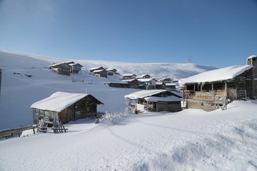 mountain landscape slopes covered with snow can be seen a tree fence and a house.savsat/artvin