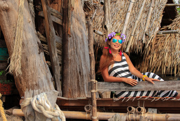Thai girls relax and have fun, wood house backdrop on the beach, Ko Phayam, Thailand