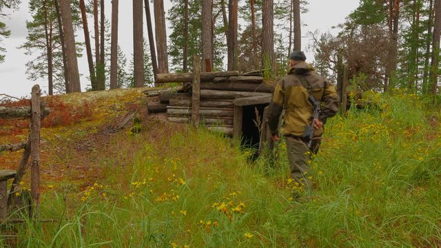 The huntsman examines the shelter of poachers in the forest on the shores of Lake Onega. Karelia, Russia.