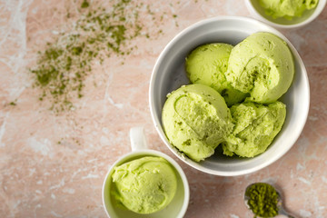 Balls of vegetarian ice cream with matcha tea in a white porcelain bowl on a marble background. top view image