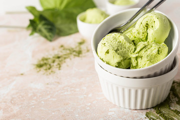 Balls of vegetarian ice cream with matcha tea in a white round plate on a marble background. horizontal image and copy space.
