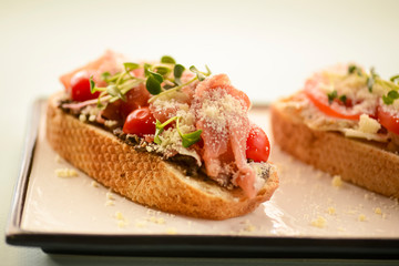 Traditional Italian bruschetta with parmesan cheese, tomato, prosciutto meat, mushrooms, seasoned with herbs