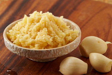 Grated garlic in dish on table 