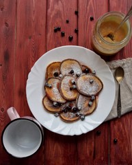 Top view fritters with berries for breakfast on brown wooden background