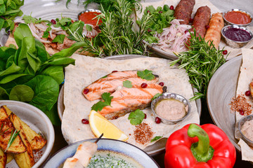 Traditional Georgian cuisine. Salmon steak with sauce, harcho soup, dolma chanakhi chashululi kupati meat and veggies