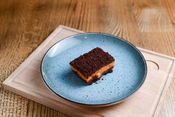 A piece of pumpkin spice cake served on a blue plate in a restaurant.