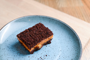 A piece of pumpkin spice cake served on a blue plate in a restaurant.