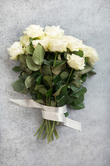 Bouquet of white roses on grey. Top view, copy space.
