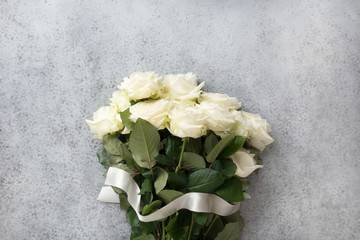 Bouquet of white roses on grey. Top view, copy space.