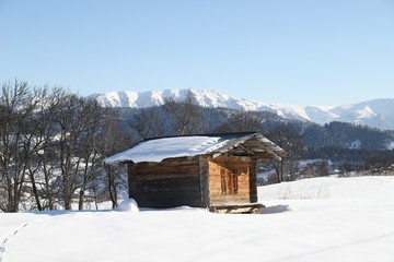 mountain landscape slopes covered with snow can be seen a tree fence and a house.savsat/artvin