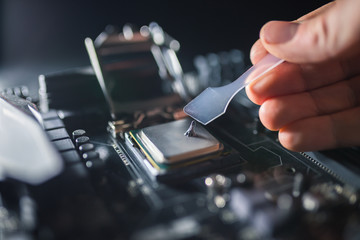 Technical support worker greases with thermal grease paste computer processor. Thermal compound on...