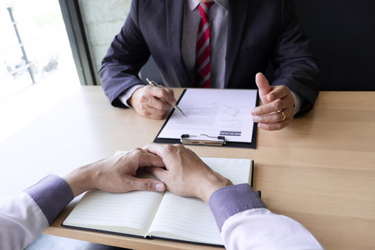 Interview employee talking about resume and job description with the job seeker sitting in front