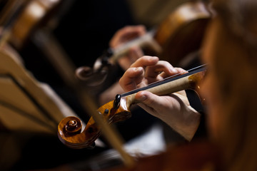 Hand of a musician playing the violin in an orchestra close-up