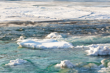 Fototapeta premium Fragment of a mountain river in winter closeup 