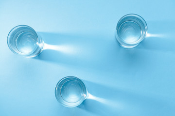 Glasses of clean water on color background