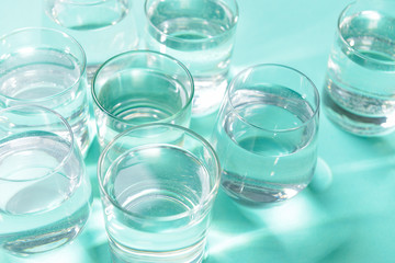 Glasses of clean water on color background