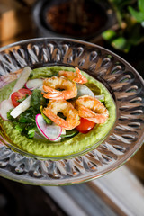 Canape with cucumber, avocado mousse, salmon and shrimp on white wooden background, selective focus