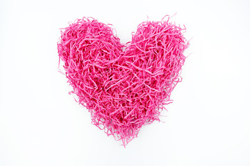 Close up top view of shredded pink spaghetti paper in shape of heart isolated on white background. For valentine's, love, heart, heath, proposal, wedding, anniversary, dating and romance concept.