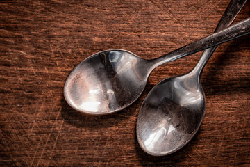 Closeup spoon placed on the floor of an old wooden chopping board with warm light in the kitchen
