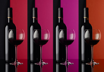 Glasses and bottles of red wine on a black background.