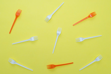 Plastic forks on yellow background.