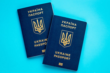 Two ukrainian biometric passports on blue background. Planning vacation concept. International passport.