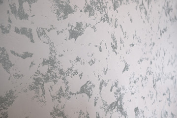 Marble background or texture. The decorative marble plaster painted on the wall mimics the natural marble surface. The combination of gray and white