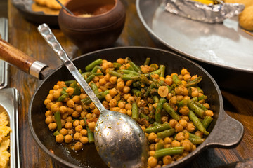 vegetarian dish of beans and chickpeas in an open kitchen in a cafe