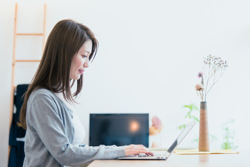 家でパソコンで仕事をする女性
