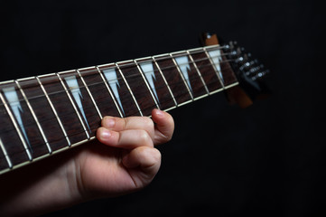 Children's hand close up learning guitar playing