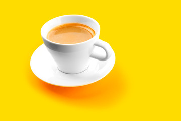 Black coffee in a cup on a yellow background